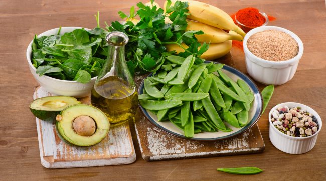 Foods highest in Vitamin K on wooden board.